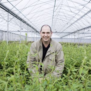 Arnaud Travers et une serre de production de clématites - © Pépinières Travers